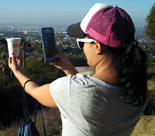 Nidal takes a photo of her coffee cup with the city in the backdrop.