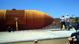 Onlookers gather on a rooftop to take photos of ET-94 as it rolls down Manchester Boulevard in Inglewood...on May 21, 2016.