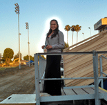 Usha (with a weird glow around her) poses near the stadium bleachers at our high school alma mater.