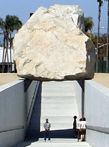 Posing for a photo beneath (um, sort of) 'Levitated Mass.'