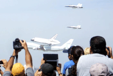 Followed by two F-18 chase planes, the Shuttle Carrier Aircraft ferrying Endeavour flies over LAX on September 21, 2012.