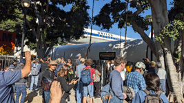 The crowd of onlookers watches as one of Endeavour's two solid rocket motors enters the premises at Exposition Park in Los Angeles...on October 11, 2023.