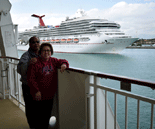 My folks pose as the Carnival Victory sets sail behind them.