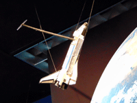 A space shuttle model on display inside the JPL museum.