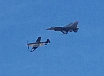 A P-51 Mustang and an F-16 Fighting Falcon fly alongside each other during an air demo above Miramar MCAS...on September 24, 2016.