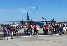 The C-130 Hercules is surrounded by crowds of people as the air demo takes place in the distance...on September 24, 2016.