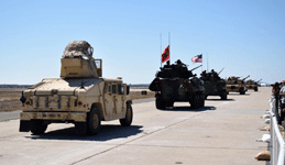 A Humvee follows behind the LAV-25 Light Armored Vehicles and M1A1 Abrams tanks on the tarmac at MCAS Miramar...on September 29, 2018.