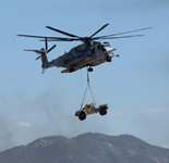 A CH-53 Sea Stallion is about to lower a military truck onto the airfield during the MAGTF demo at the Miramar Air Show...on September 24, 2022.