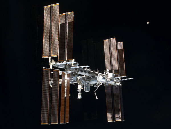 The International Space Station (ISS) with the Moon in the background, as seen from space shuttle Atlantis after she undocked from the ISS on July 18, 2011, Pacific Daylight Time