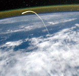 The plasma trail caused by space shuttle Atlantis as she re-entered Earth's atmosphere is photographed from the ISS on July 21, 2011