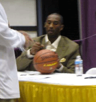 Kobe Bryant autographs a basketball.